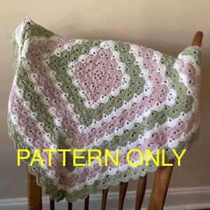 May include: A crocheted blanket in shades of pink, white, and green, draped over a wooden chair. The blanket features a square pattern with a scalloped edge. The text "PATTERN ONLY" is visible in yellow.