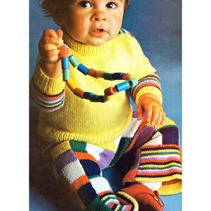 May include: A baby in a yellow sweater, colourful knit trousers, and shoes, holding a necklace of wooden beads. The image has the word "preserve" at the top and bottom. The trousers and sleeves have striped patterns.
