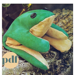 Könnte beinhalten: Eine grüne und braune Froschpuppe mit schwarzen Augen. Die Puppe sitzt auf einem Baumstamm. Der Text "pdf" ist in der linken unteren Ecke des Bildes sichtbar.
