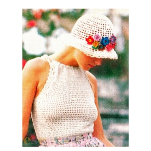 May include: A white crocheted halter top with a white crocheted hat featuring a band of colorful crocheted flowers.