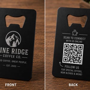 May include: A rectangular black metal bottle opener featuring the Pine Ridge Coffee Co. logo with a mountain graphic on the front. The back displays a QR code with the text Scan to connect with us online and Follow us for special offers, new blends & more.