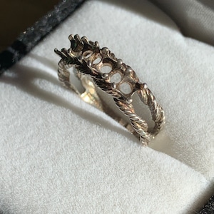 May include: Silver ring setting with five open prongs for a center stone and a twisted rope design.