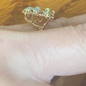 Op de afbeelding: Een gouden ring met drie opalen gezet in een bloemmotief.