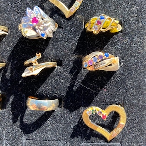 Mother rings samples. , two pins, brass . Assorted sizes and stones
