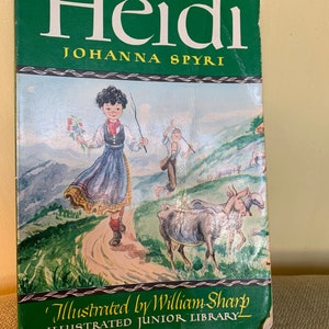 May include: A vintage hardcover book titled "Heidi" by Johanna Spyri. The book cover features an illustration of a young girl in a blue and white dress walking on a path with goats and a boy in the background. The text "Illustrated by William Sharp" and "Illustrated Junior Library" is printed on the bottom of the cover.