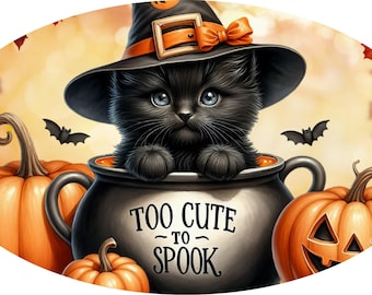 May include: A black kitten wearing a witch hat sits in a cauldron with the text "Too Cute to Spook." The image features orange pumpkins and bats, set against a warm, autumnal background. A charming Halloween-themed illustration.