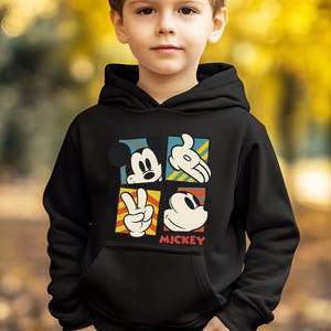May include: Black hooded sweatshirt with a colorful graphic of Mickey Mouse in different poses. The graphic includes the text "MICKEY".