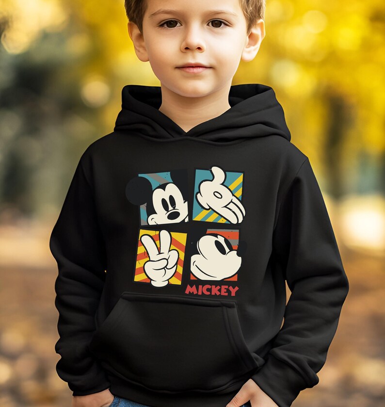 May include: Black hooded sweatshirt with a colorful graphic of Mickey Mouse in different poses. The graphic includes the text "MICKEY".