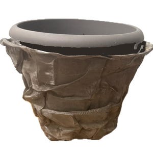 May include: A decorative, textured brown planter with a gray rim. The planter has a unique, crumpled appearance, adding a rustic touch. Ideal for indoor or outdoor use, it provides a stylish home for plants.