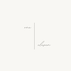 Op de afbeelding: Minimalistisch ontwerp met het woord "one" boven een verticale lijn en het woord "eleven" eronder, allemaal in een delicaat, handgeschreven lettertype. De achtergrond is een zachte, neutrale kleur.