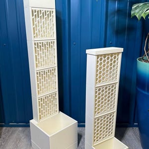May include: Two white planter boxes with geometric lattice designs. The planter on the left has a diamond pattern and the planter on the right has a honeycomb pattern.