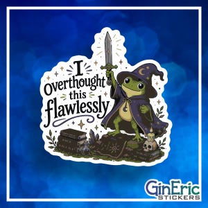 May include: A die-cut sticker featuring a green frog wearing a purple wizard hat and robe, holding a sword aloft. The text reads I Overthought this flawlessly. The frog stands on a stack of books next to a skull, a candle, and a small potion bottle.