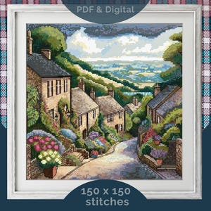 Könnte beinhalten: Gerahmte Kreuzstich-Landschaft, die ein malerisches Dorf in einem Tal darstellt. Das Kunstwerk zeigt Steingebäude, üppiges Grün und eine kurvenreiche Straße. Der Text "PDF & Digital" und "150 x 150 Stiche" sind sichtbar.