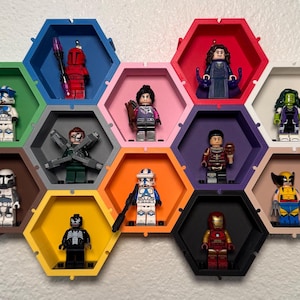 May include: A wall display of 12 hexagonal shelves, each featuring a different Lego minifigure. The shelves are painted in various colors, including blue, red, green, pink, purple, brown, yellow, and black. The minifigures include characters from Star Wars, Marvel, and other popular franchises.