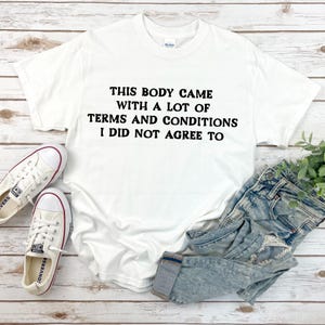 May include: White t-shirt with black text that reads "This body came with a lot of terms and conditions I did not agree to".