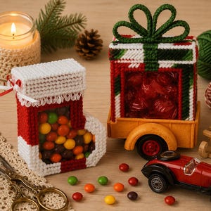 May include: A plastic canvas Christmas stocking filled with multi-coloured sweets and a plastic canvas gift box with a green yarn bow, also filled with red sweets, sitting on a yellow toy trailer attached to a red toy car with metal scissors.