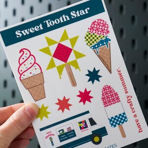 May include: A sticker sheet titled "Sweet Tooth Star" featuring ice cream cones, popsicles, and star-shaped designs. The sheet includes a graphic of an ice cream truck and the text "have a crafty summer."
