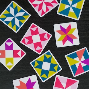ini quilt block sticker set of 10 featuring bold geometric star and block designs in either bold and bright or soft and neon colorways. Each 1"x1" sticker is individually cut and packed. Waterproof vinyl, gloss laminated. Sticks to water bottles, laptops, planners, and sewing machines. The collector's set for the modern quilter — perfect for quilt retreat goodie bags and guild gifts.