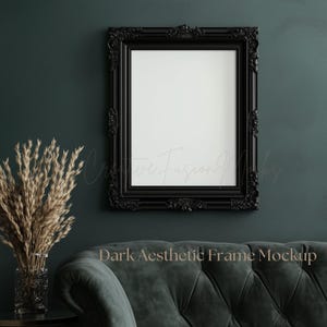 May include: A black ornate frame mockup with a white background, hanging on a dark green wall. The frame is in front of a dark green velvet tufted sofa. "Dark Aesthetic Frame Mockup" is written in white text on the sofa.