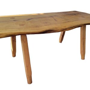 May include: A rustic wooden table with a natural edge and four angled legs. The table is made of light-colored wood and appears to be handmade. The table is approximately 48 inches long and 24 inches wide.