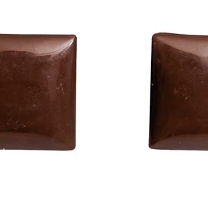 May include: Two square, dark brown earrings with rounded corners. The earrings have a glossy finish and are set against a white background. The earrings are a simple, minimalist design.