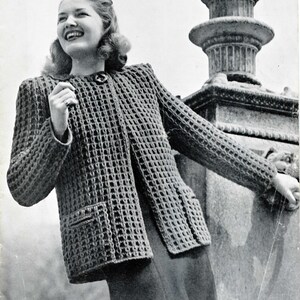 May include: A black and white photo of a woman wearing a crocheted jacket. The jacket has a waffle stitch pattern and a pocket on the left side. The woman is standing in front of a stone fountain.