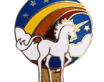Puede incluir: Un unicornio blanco con un cuerno dorado se encuentra frente a un arcoíris y estrellas sobre un fondo azul. El unicornio está rodeado de nubes blancas.