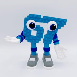 May include: A whimsical blue figure in the shape of the number 67, with large googly eyes, arms, legs, and hands. The figure is wearing gray and white sneakers and has blue and white striped sleeves. The figure is standing on a white surface.