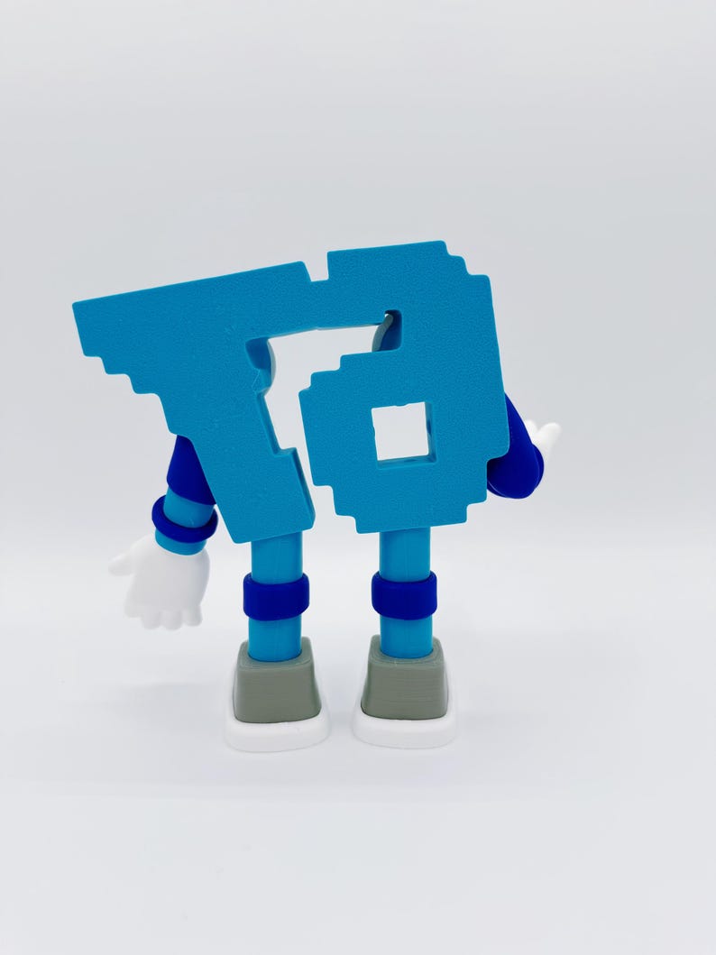 May include: A blue, pixelated number 6 figure with arms, legs, and white gloves. The figure has a light blue body, dark blue arms and legs, and gray and white shoes. The figure is standing on a white surface.