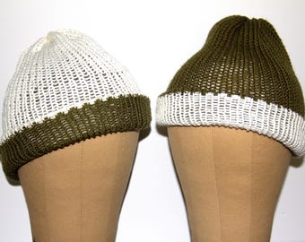 Puede incluir: Dos gorros de punto con un esquema de color blanco y verde oliva. Los gorros se muestran en maniquíes marrones.