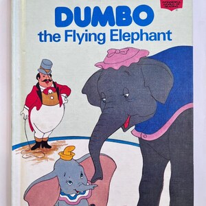 May include: A vintage copy of "Dumbo the Flying Elephant" book. The cover features illustrations of Dumbo, a circus ringmaster, and other characters. The title is in blue, with the Walt Disney's logo at the top.