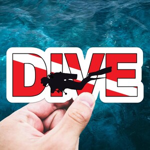 May include: A die-cut sticker featuring the word DIVE in bold capital letters. The letters have a red and white diagonal stripe pattern resembling a diver down flag. A black silhouette of a scuba diver is centered over the letters.