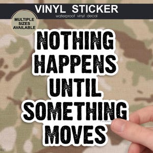 May include: A white vinyl sticker with a black distressed font that reads NOTHING HAPPENS UNTIL SOMETHING MOVES. The sticker has a white border and is displayed against a camouflage background with a circular badge stating MULTIPLE SIZES AVAILABLE.