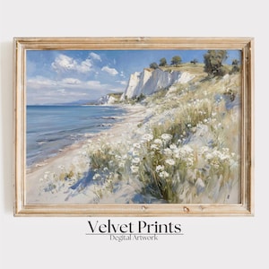 May include: A framed landscape painting shows a coastal scene with white cliffs, a sandy beach, and a blue ocean under a partly cloudy sky. White wildflowers and green grass are in the foreground. The text "Velvet Prints Digital Artwork" is at the bottom.