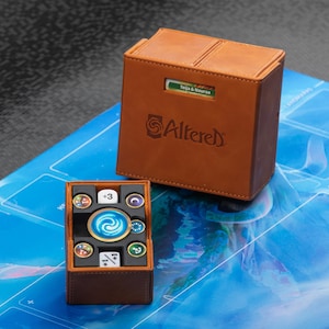 May include: A brown leather deck box with the word "Altered" printed on the front. The box is open and a brown dice tray with a blue swirl design is visible. The dice tray contains various dice with different numbers and symbols.