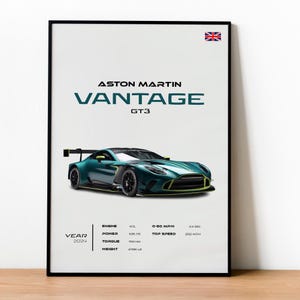 Op de afbeelding: Een ingelijste poster met een Aston Martin Vantage GT3 raceauto in teal en zwart. De poster toont "ASTON MARTIN VANTAGE GT3" en specificaties zoals motorinhoud, vermogen, koppel en gewicht (1229 kg). De Britse vlag staat rechtsboven.