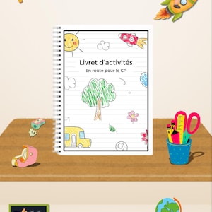 May include: An activity book titled "Livret d'activités" with drawings of a sun, tree, bus, and rocket. A cartoon boy rides a rocket. School supplies and a globe are also present. The book is spiral-bound.