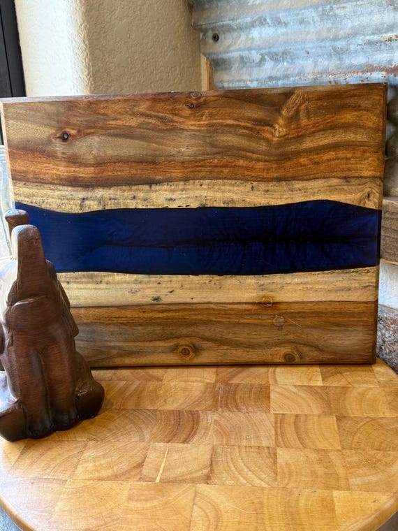 Handcrafted resin-and-wood cutting board where the poured resin creates a river, galaxy, or abstract art effect — no two are identical.