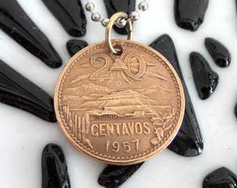 Könnte beinhalten: Eine kupferfarbene 20-Centavos-Münze aus dem Jahr 1957 mit einer Bergkette und Sonnenstrahlen, an einer Kettenkette.