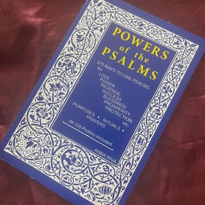 Puede incluir: Un libro azul titulado "POWERS of the PSALMS" con texto blanco y amarillo. La portada del libro presenta un dise&ntilde;o de borde blanco adornado. El libro enumera prop&oacute;sitos para usar los Salmos, incluyendo amor, poder y protecci&oacute;n. La autora es Anna Riva.