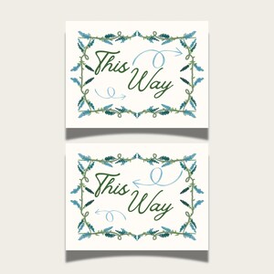 May include: Two rectangular cards with the words "This Way" in green script, accompanied by a light blue arrow. The cards are framed with a border of green and blue leaves and vines. The background is a light cream color.