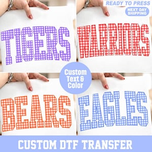 May include: Four white fabric sheets featuring heat transfer designs with block lettering. The top left shows purple gingham TIGERS, top right red gingham WARRIORS, bottom left orange gingham BEARS, and bottom right blue gingham EAGLES text.