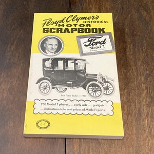 Könnte beinhalten: Ein Vintage-Buch mit dem Titel "Floyd Clymer's Historical Motor Scrapbook" mit einem Schwarz-Weiß-Bild eines Ford Model T. Das Cover ist gelb und weiß mit Text und einem Porträt eines Mannes. Das Buch enthält Informationen über Model T-Autos.