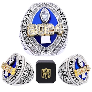 May include: A silver and gold championship ring with blue and white accents. The ring features a football trophy and the text "Fantasy League Champion 2024".
