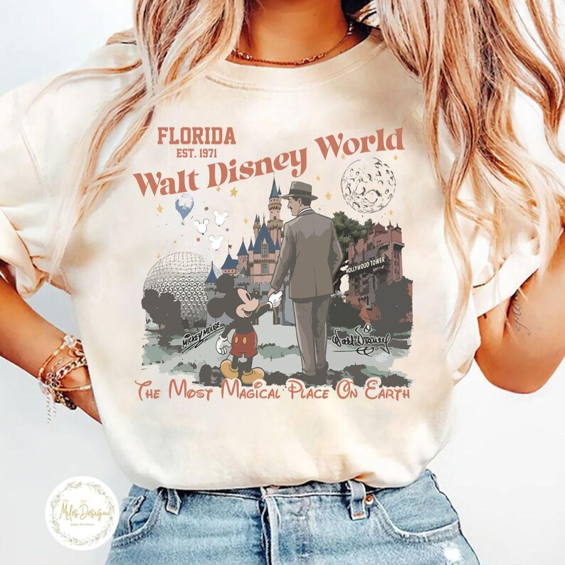 Puede incluir: Camiseta color crema con un gr&aacute;fico de estilo vintage de Walt Disney World en Florida. El dise&ntilde;o incluye a Mickey Mouse, un hombre con traje, un castillo y el texto "The Most Magical Place on Earth".