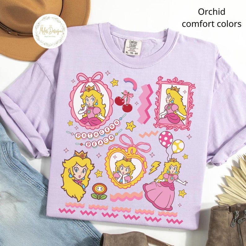 May include: Orchid-colored t-shirt with multiple Princess Peach graphics. The shirt features various illustrations of the character in pink frames, hearts, and other decorative elements. The text "Princess Peach" is also displayed.
