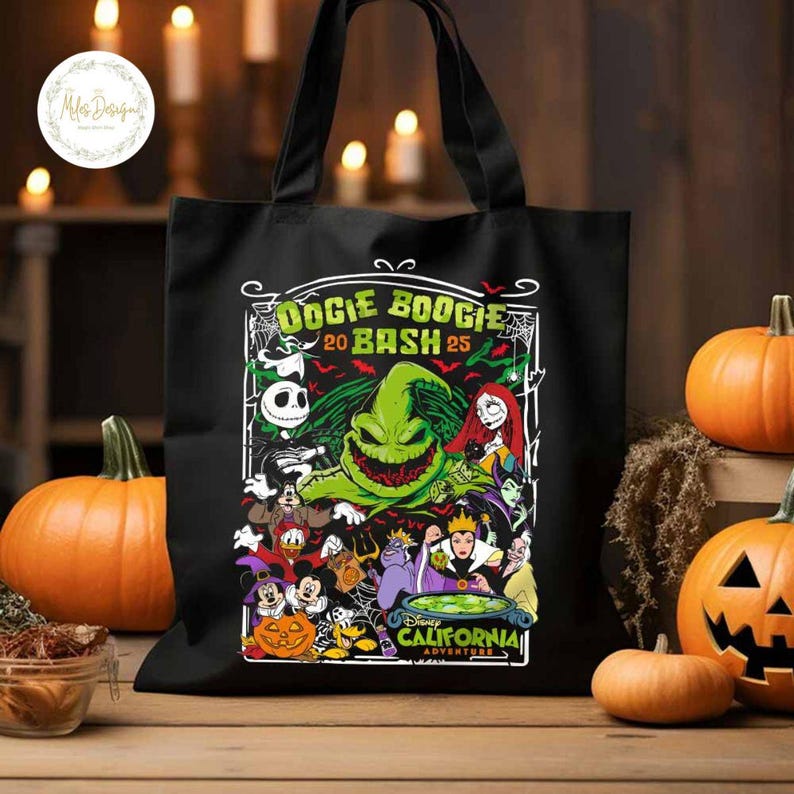 May include: Black tote bag featuring a colorful graphic for the Oogie Boogie Bash 2025 event at Disney California Adventure. The design includes characters like Jack Skellington, Sally, and Oogie Boogie. Pumpkins are in the background.
