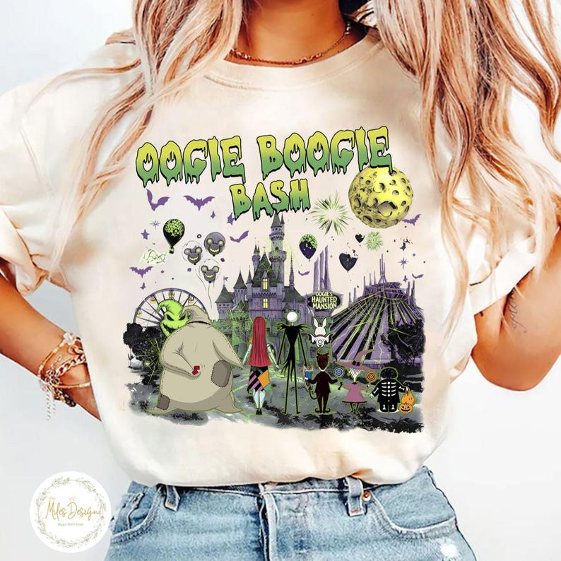 May include: Cream-colored t-shirt featuring a colorful graphic of characters and scenes from "The Nightmare Before Christmas" movie. The text "Oogie Boogie Bash" is in green above the image. The design includes a castle, a Ferris wheel, and a full moon.