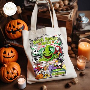 May include: A cream-colored tote bag featuring a colorful graphic of characters from The Nightmare Before Christmas and other Disney villains. The text "Oogie Boogie Bash 20 Bash" is displayed at the top. Orange carved pumpkins and lit candles surround the bag.