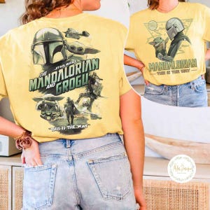 Peut inclure: T-shirt jaune avec des graphismes de la s&eacute;rie Star Wars, "The Mandalorian". L'avant et l'arri&egrave;re du t-shirt pr&eacute;sentent des images du Mandalorien, de Grogu et de vaisseaux spatiaux. Le texte sur le t-shirt comprend "The Mandalorian and Grogu" et "This is the Way."
